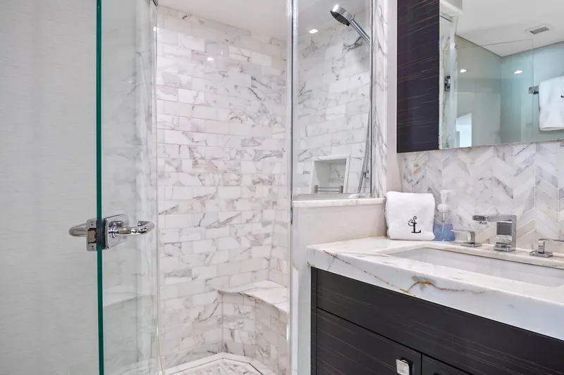 Surplus Lines Yacht Photos Pics Luxurious marble bathroom in 2019 Hatteras M90 Panacera yacht, featuring modern fixtures and glass shower.