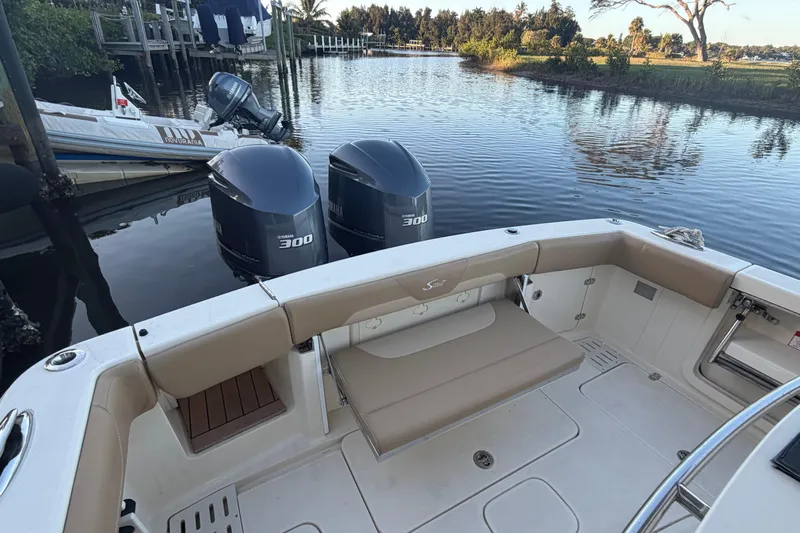  Yacht Photos Pics 2016 Scout 300 LXF boat with twin Yamaha 300 engines docked by a serene waterway.