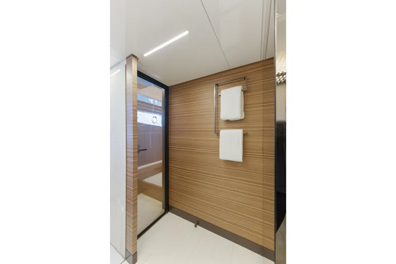 Date Night Yacht Photos Pics Luxurious bathroom interior of 2018 Ferretti Yachts 920 with modern wood paneling and towel rack.