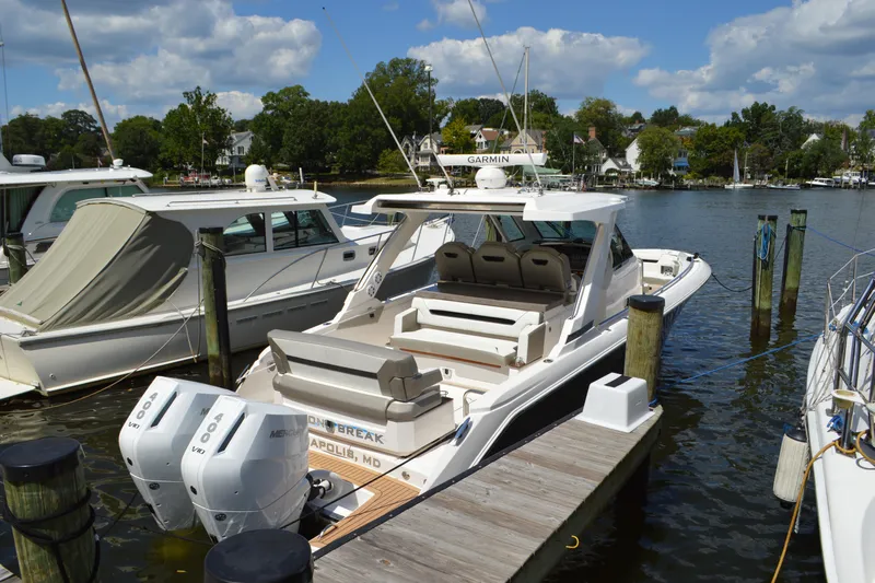 Station Break Yacht Photos Pics 2024 Tiara Yachts 34 LS docked, featuring dual Mercury outboard engines, under a partly cloudy sky.
