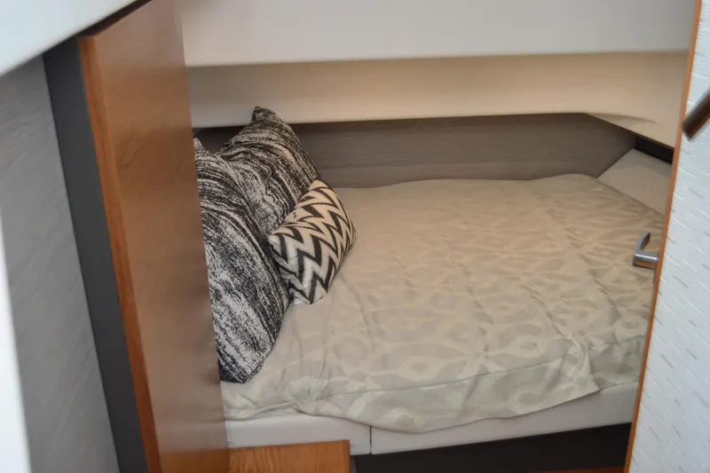 Station Break Yacht Photos Pics 2024 Tiara Yachts 34 LS cabin interior with cozy bed and patterned pillows.