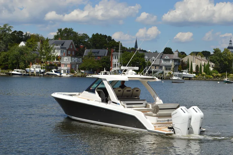 Station Break Yacht Photos Pics 2024 Tiara Yachts 34 LS cruising on a scenic waterfront with luxury homes.