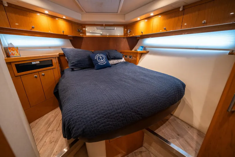 Water Break Yacht Photos Pics Luxurious 2008 Marquis 50 LS yacht bedroom with cozy bedding and elegant wood cabinetry.