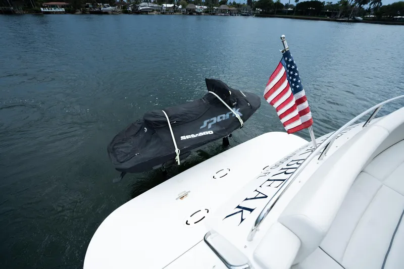 Water Break Yacht Photos Pics 2008 Marquis 50 LS yacht with American flag and covered jet ski on water.
