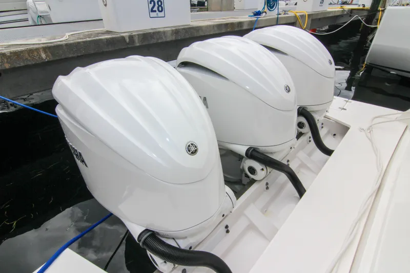  Yacht Photos Pics Triple outboard engines on a 2023 Regal 38 SAV boat docked at a marina.