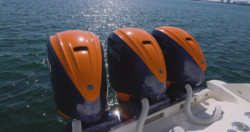  Yacht Photos Pics Triple outboard motors on a 2009 Hydra-Sports 4200 SF boat, glistening on the water.