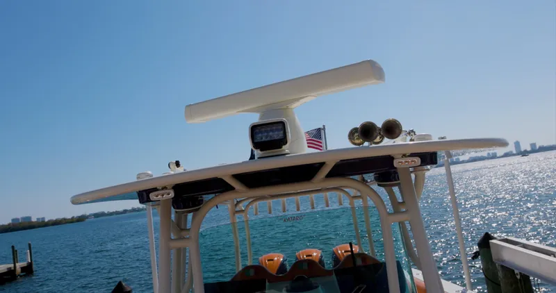  Yacht Photos Pics 2009 Hydra-Sports 4200 SF boat on water with American flag, clear sky, and city skyline.