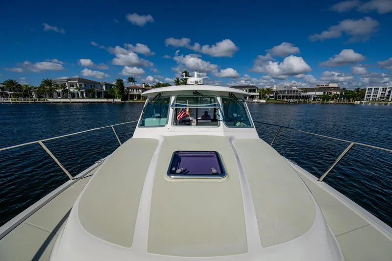  Yacht Photos Pics 2020 Back Cove 340 yacht cruising on a sunny day with waterfront homes in the background.