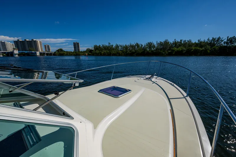  Yacht Photos Pics 2020 Back Cove 340 boat on a sunny day, with cityscape and trees in the background.