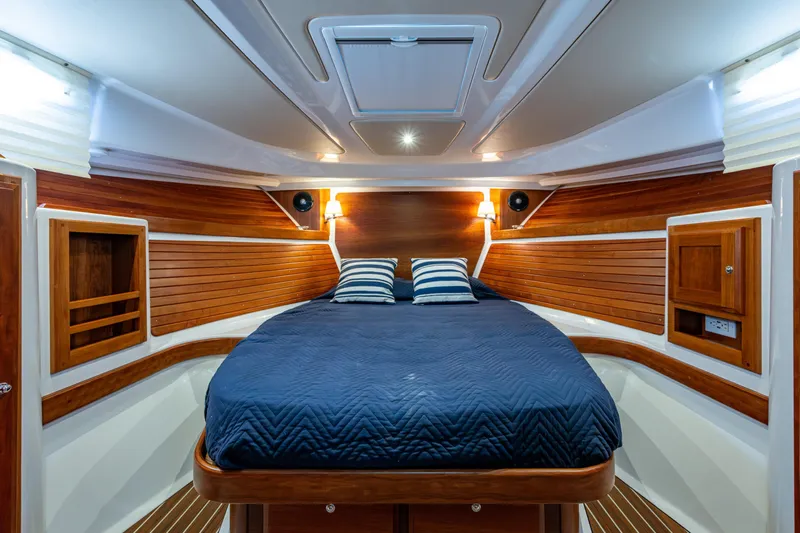  Yacht Photos Pics Luxurious cabin interior of 2020 Back Cove 340 yacht with wood paneling and cozy bedding.