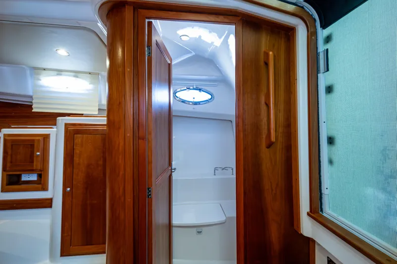  Yacht Photos Pics 2020 Back Cove 340 interior with wooden cabinetry and porthole window.