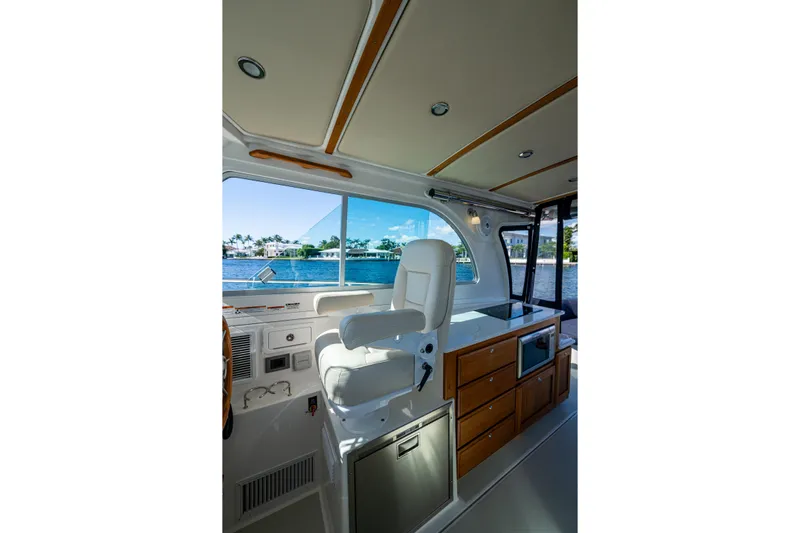  Yacht Photos Pics Interior of 2020 Back Cove 340 boat with helm seat and cabinetry, overlooking water.