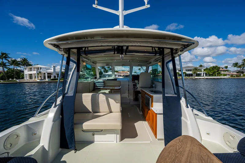  Yacht Photos Pics 2020 Back Cove 340 boat interior with seating, docked by waterfront homes.