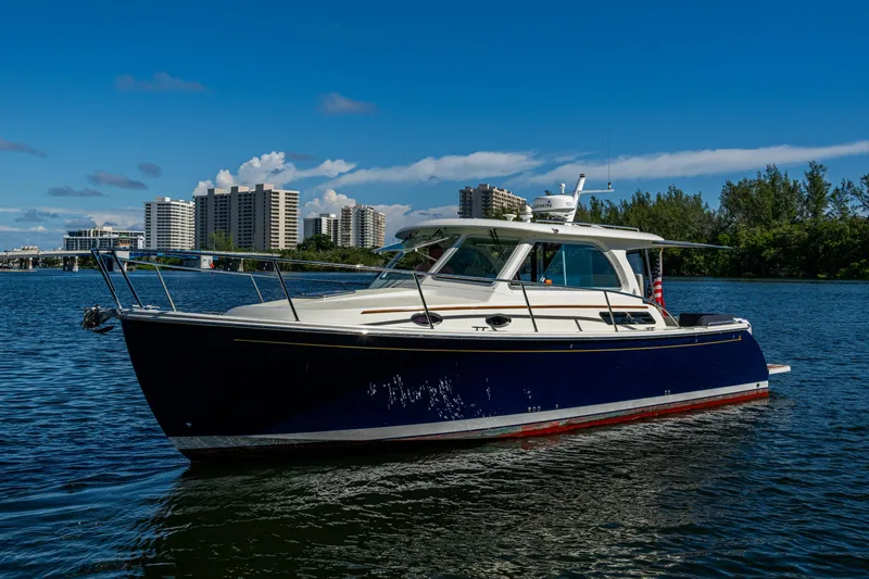 Yacht Photos Pics 2020 Back Cove 340 boat on water with cityscape background.