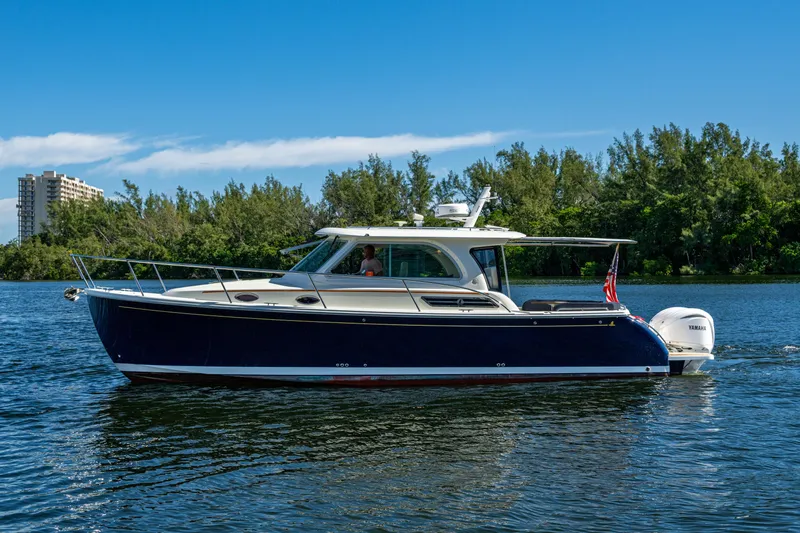  Yacht Photos Pics 2020 Back Cove 340 boat cruising on a serene waterway with lush greenery.