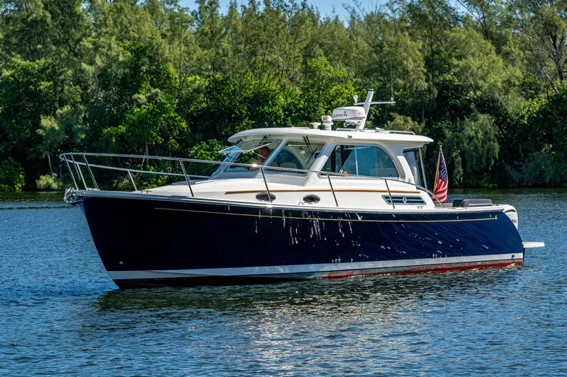  Yacht Photos Pics 2020 Back Cove 340 boat on a serene lake with lush green trees.