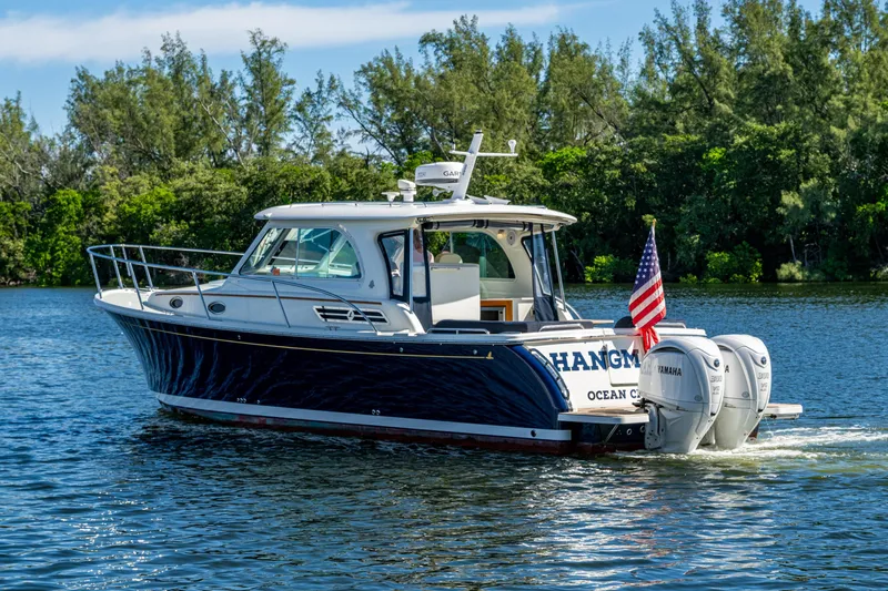  Yacht Photos Pics 2020 Back Cove 340 boat cruising on a scenic lake with lush greenery.