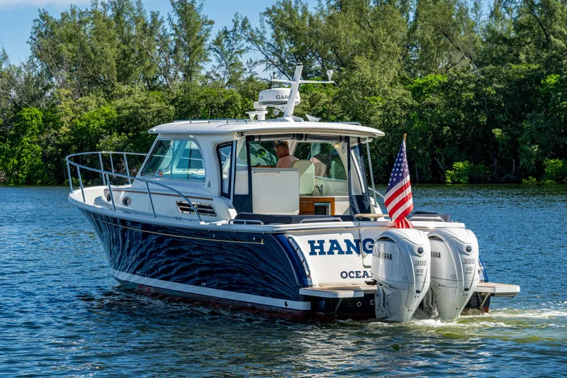  Yacht Photos Pics 2020 Back Cove 340 boat cruising on a scenic waterway with lush greenery.