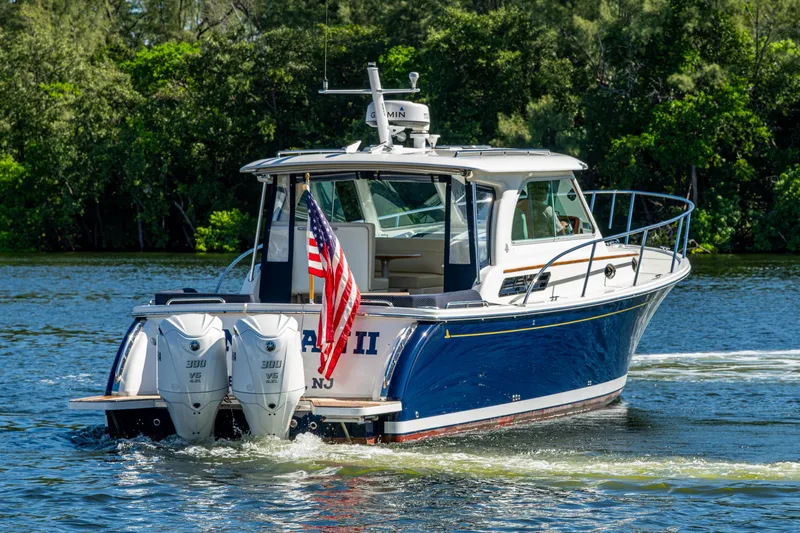  Yacht Photos Pics 2020 Back Cove 340 boat cruising on a scenic waterway with American flag.