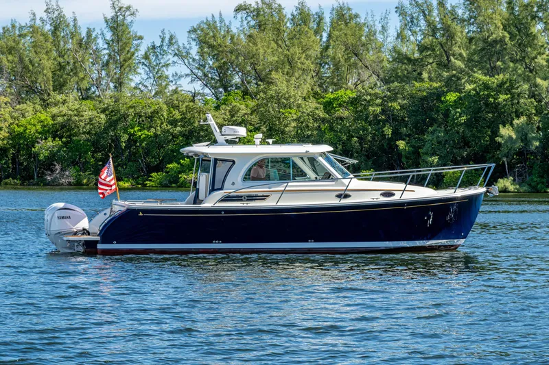  Yacht Photos Pics 2020 Back Cove 340 boat on water with lush green trees in background.