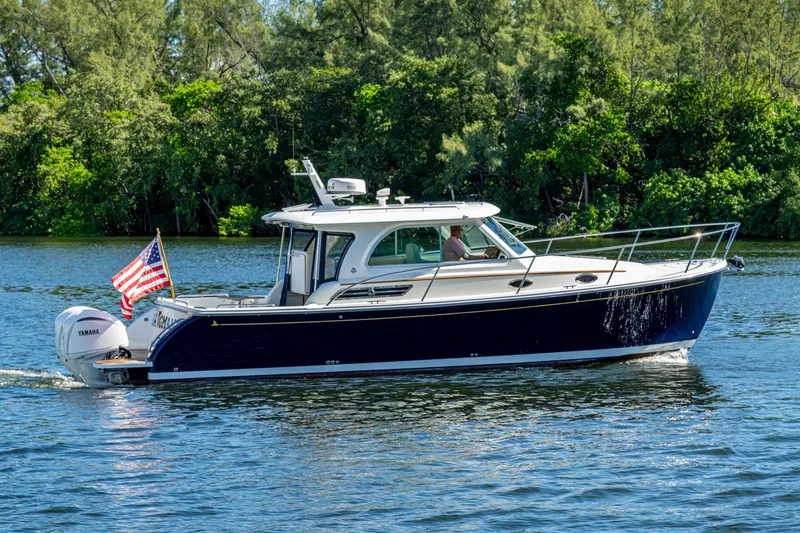  Yacht Photos Pics 2020 Back Cove 340 boat cruising on a scenic waterway with lush greenery.