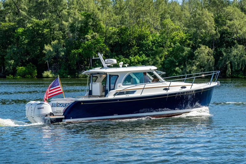 Yacht Photos Pics 2020 Back Cove 340 boat cruising on a scenic river with lush greenery.
