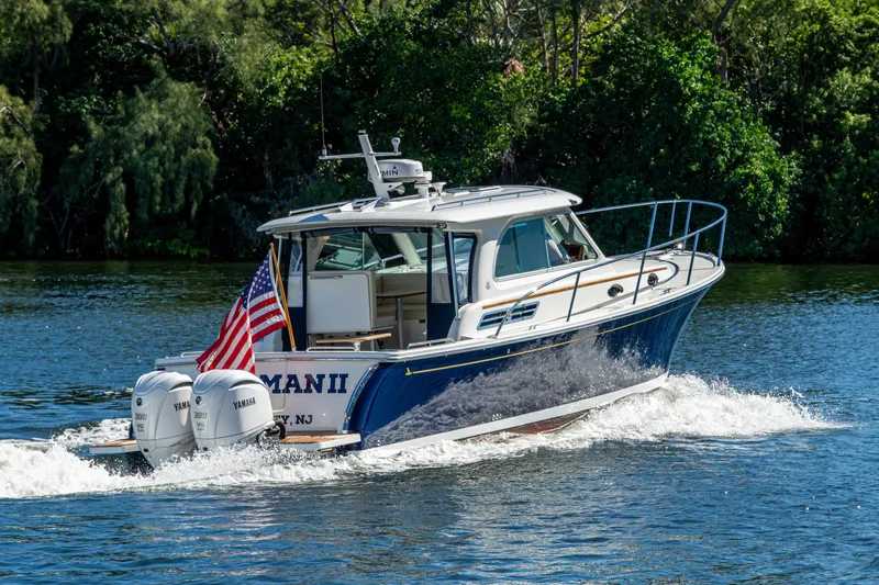  Yacht Photos Pics 2020 Back Cove 340 boat cruising on a scenic waterway with lush greenery.