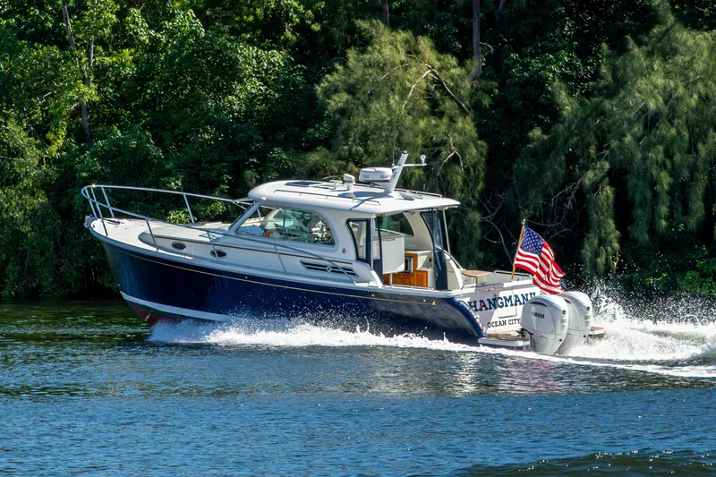  Yacht Photos Pics 2020 Back Cove 340 boat cruising on a river with lush greenery background.