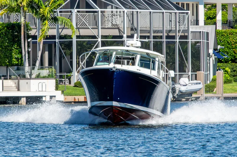  Yacht Photos Pics 2020 Back Cove 340 boat cruising on water near waterfront property.