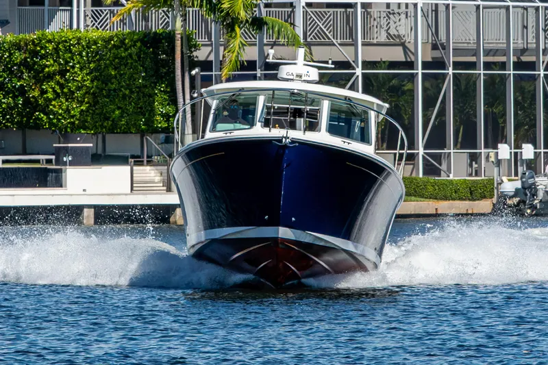  Yacht Photos Pics 2020 Back Cove 340 boat cruising on water near waterfront buildings.