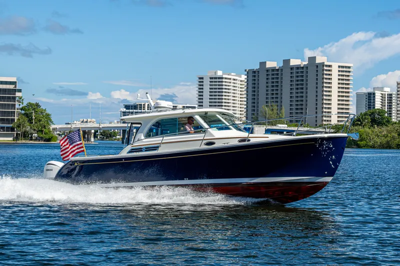  Yacht Photos Pics 2020 Back Cove 340 cruising on water with city skyline in background.