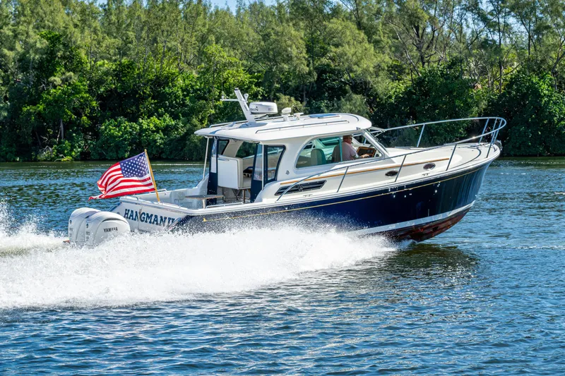  Yacht Photos Pics 2020 Back Cove 340 boat cruising on a scenic waterway with American flag.