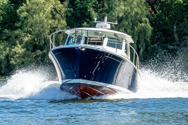 Yacht Photos Pics 2020 Back Cove 340 boat cruising on water with lush greenery background.