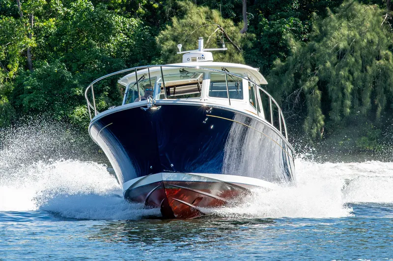  Yacht Photos Pics 2020 Back Cove 340 boat cruising on water with lush greenery background.