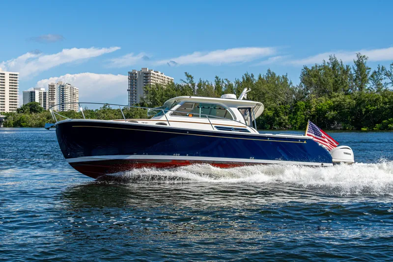  Yacht Photos Pics 2020 Back Cove 340 boat cruising on water with cityscape background.