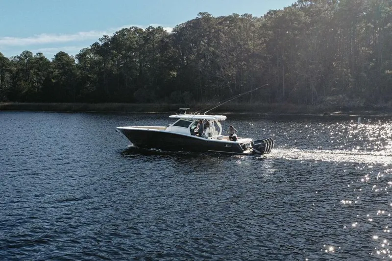 O-sea-d Yacht Photos Pics 2020 Scout 380 LXF boat cruising on a serene lake with forest backdrop.