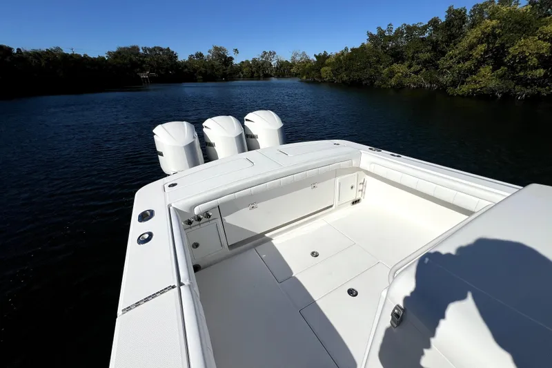  Yacht Photos Pics 2018 Regulator 34 Center Console boat with triple engines on a calm waterway.