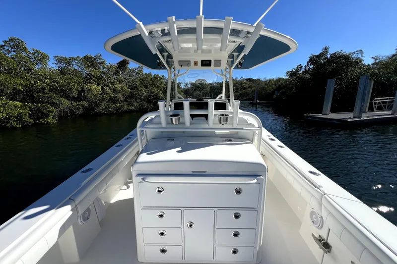  Yacht Photos Pics 2018 Regulator 34 Center Console boat on calm water, surrounded by lush greenery.