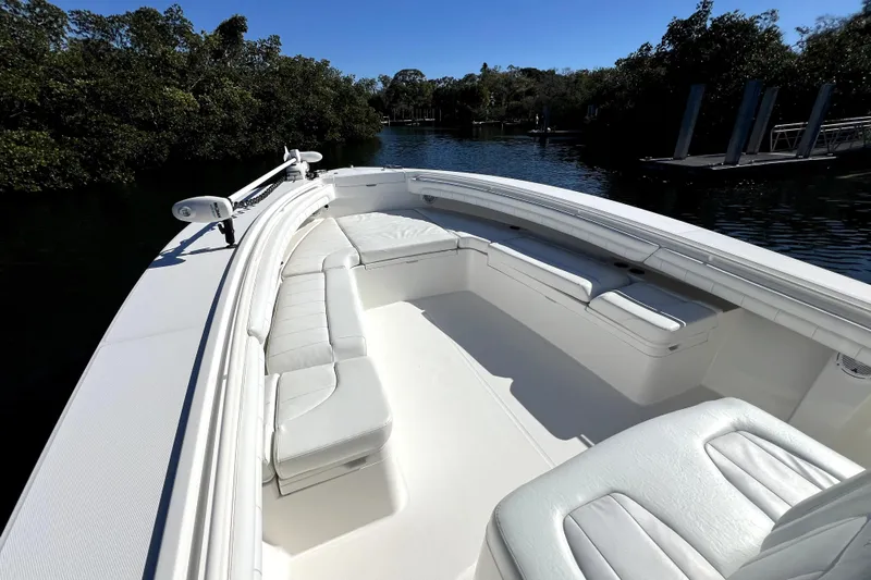  Yacht Photos Pics 2018 Regulator 34 Center Console boat with spacious seating, docked near lush greenery.