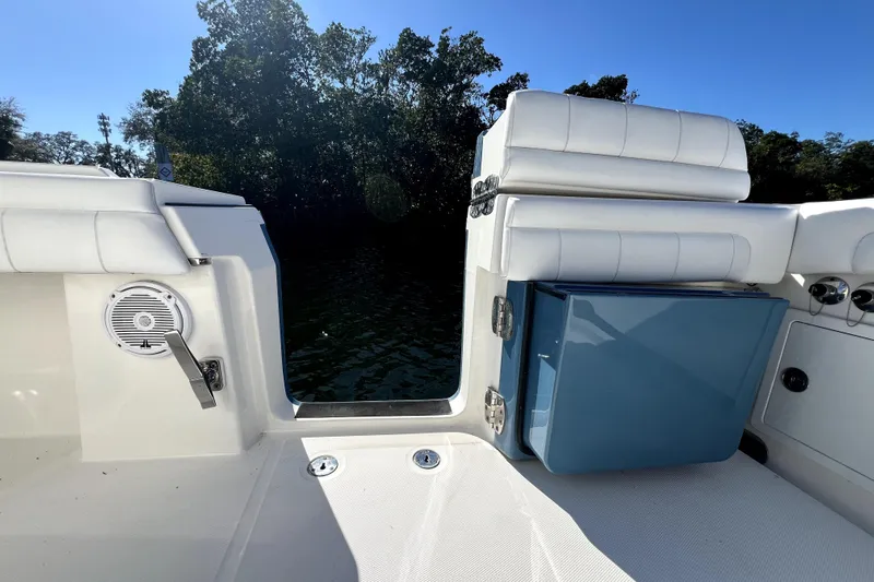  Yacht Photos Pics 2018 Regulator 34 Center Console boat interior with seating and storage, surrounded by water and trees.