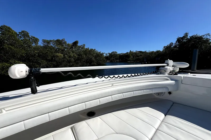  Yacht Photos Pics 2018 Regulator 34 Center Console boat with white seating and trolling motor, near water.