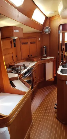 Hasard III Yacht Photos Pics Interior of 1986 Baltic 48 DP sailboat with wooden cabinetry and modern kitchen amenities.