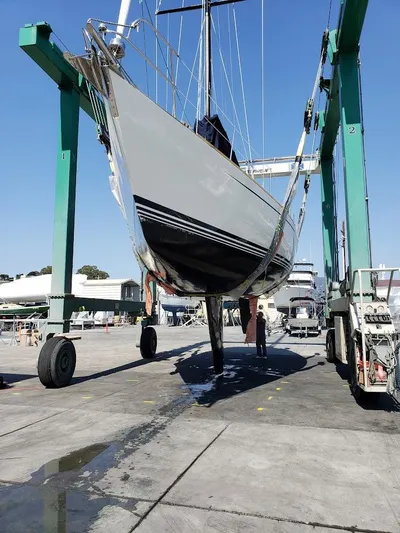Hasard III Yacht Photos Pics Baltic 48 DP 1986 sailboat being lifted by a boat hoist in a marina.