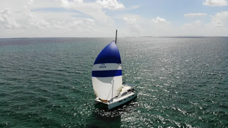  Yacht Photos Pics Sailboat Leopard 46 (2011) with blue and white sail on open sea under clear sky.