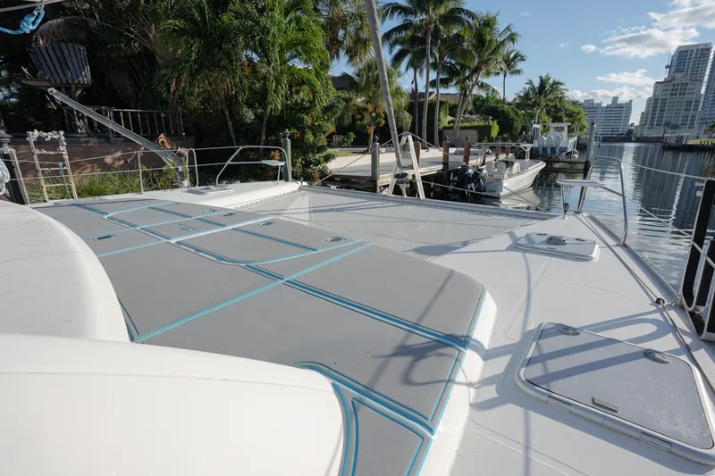  Yacht Photos Pics 2011 Leopard 46 yacht deck with sunbathing area, docked near palm trees and waterfront buildings.