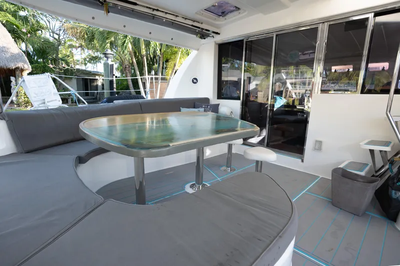  Yacht Photos Pics Spacious outdoor seating area on 2011 Leopard 46 yacht with glass table and cushioned benches.