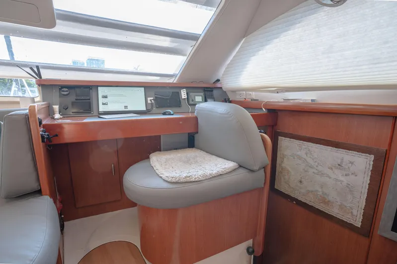  Yacht Photos Pics Navigation station inside 2011 Leopard 46 yacht with wooden desk and cushioned seat.