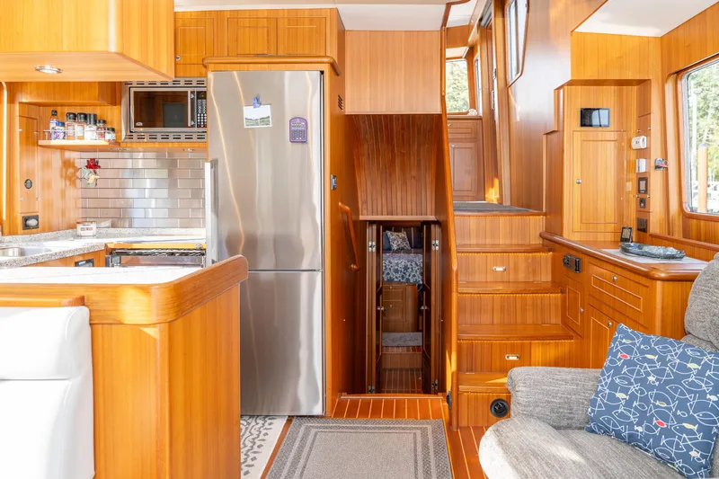 Northern Reign Yacht Photos Pics Luxurious 2020 North Pacific 45 Pilothouse interior with modern kitchen and wooden finishes.