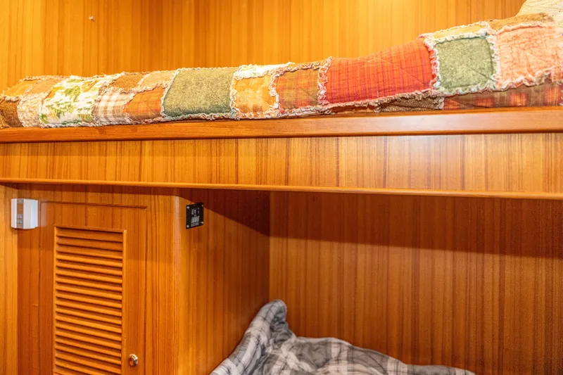 Northern Reign Yacht Photos Pics Cozy cabin interior of 2020 North Pacific 45 Pilothouse with wooden finish and patchwork quilt.