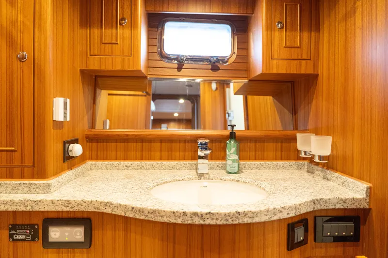 Northern Reign Yacht Photos Pics Luxurious bathroom in 2020 North Pacific 45 Pilothouse yacht with wooden cabinetry and granite countertop.